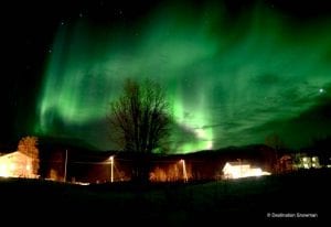 Northern lights behind buildings Arctic Norway