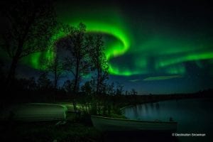 northern lights night sky boats river trees