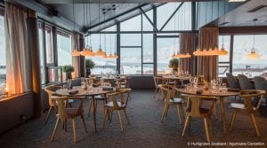 Set tables with daytime window view of mountains in restaurant at Funken Lodge in Svalbard, Arctic Norway