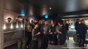 Conference room of people talking in groups with champagne glasses in Funken Lodge, Svalbard