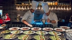 Two chefs preparing seafood meals in kitchen of restaurant at Funken Lodge in Svalbard, Arctic Norway
