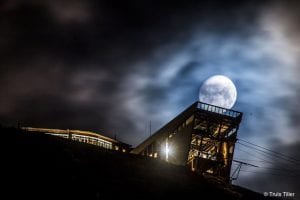 Clarion The Edge Hotel in the dark behind a full moon in Tromsø town centre, Arctic Norway