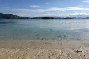 Sommarøy Beach with clear turqoise water on a clear summer day in Sommarøy, Norway