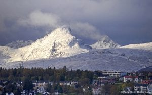 Arctic Norway Snow on Mountain Peaks behind town rooftops