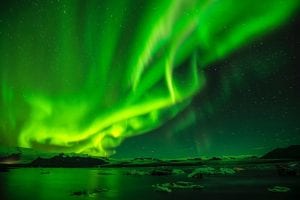 Northern Lights Aurora Borealis in the sky above water and ice