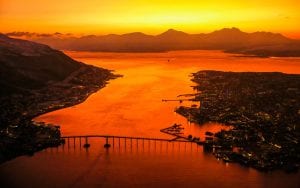 Midnight Sun aerial shot in Tromso Norway with the city and bridges and mountain fjords